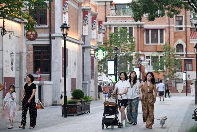 (250712) -- TIANJIN, July 12, 2025 (Xinhua) -- Tourists enjoy leisure time at the Wudadao historical urban area in north China's Tianjin, July 9, 2025. The Minyuan 1920 Block, a recently completed infrastructure enhancement project, has officially opened to the public. The project transforms sections of Hunan Road and Luoyang Avenue into a pedestrian zone and connects Minyuan Square and Wudadao Park, injecting vitality into the century-old historical area. (Xinhua/Zhao Zishuo)