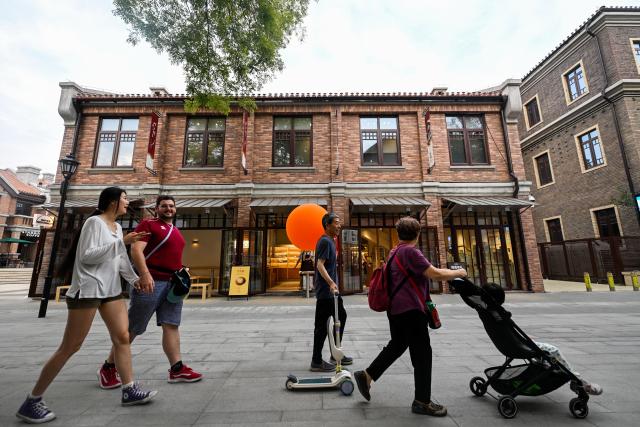(250712) -- TIANJIN, July 12, 2025 (Xinhua) -- Tourists enjoy leisure time at the Wudadao historical urban area in north China's Tianjin, July 9, 2025. The Minyuan 1920 Block, a recently completed infrastructure enhancement project, has officially opened to the public. The project transforms sections of Hunan Road and Luoyang Avenue into a pedestrian zone and connects Minyuan Square and Wudadao Park, injecting vitality into the century-old historical area. (Xinhua/Zhao Zishuo)