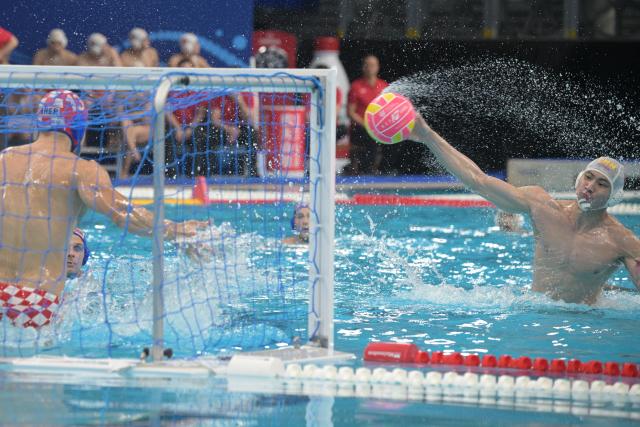 (250712) -- SINGAPORE, July 12, 2025 (Xinhua) -- Cai Yuhao (R) of China shoots the ball during the men's water polo preliminary match between China and Croatia at World Aquatics Championship 2025 in Singapore on July 12, 2025. (Xinhua/Then Chih Wey)