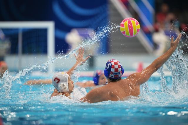 (250712) -- SINGAPORE, July 12, 2025 (Xinhua) -- Li Deming (L) of China competes during the men's water polo preliminary match between China and Croatia at World Aquatics Championship 2025 in Singapore on July 12, 2025. (Xinhua/Then Chih Wey)