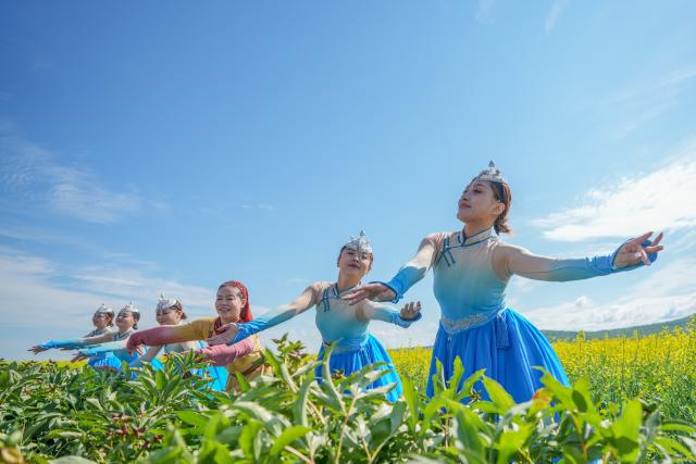 (250712) -- HULUN BUIR, July 12, 2025 (Xinhua) -- Actresses perform in a rapeseed flower field in Ergun of Hulun Buir, north China's Inner Mongolia Autonomous Region, July 12, 2025. (Xinhua/Ma Jinrui)