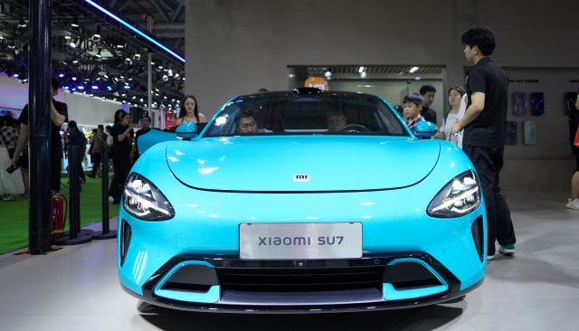 (250712) -- CHANGCHUN, July 12, 2025 (Xinhua) -- Visitors view a car of Xiaomi SU7 series at the 22nd Changchun International Auto Expo in Changchun, northeast China's Jilin Province, July 12, 2025. The 10-day expo kicked off here on Saturday, attracting 118 enterprises from home and abroad. (Xinhua/Yan Linyun)