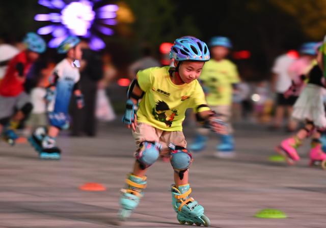 (250712) -- BEIJING, July 12, 2025 (Xinhua) -- Children practice roller skating at a square in Tengzhou City, east China's Shandong Province, July 11, 2025. Children across the country are enriching their summer vacations through colorful activities. (Photo by Li Zhijun/Xinhua)