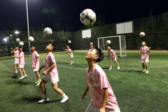 (250712) -- BEIJING, July 12, 2025 (Xinhua) -- Children attend a nighttime training at a football club in Boxing County, Binzhou City of east China's Shandong Province, July 10, 2025. Children across the country are enriching their summer vacations through colorful activities. (Photo by Chen Bin/Xinhua)