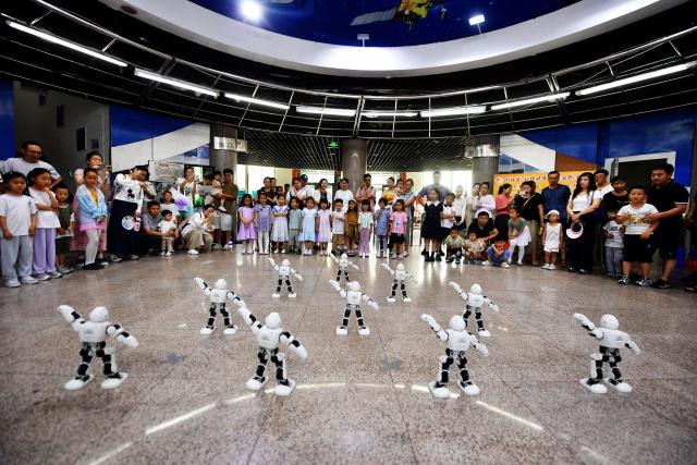 (250712) -- BEIJING, July 12, 2025 (Xinhua) -- Children of a kindergarten watch a robot dancing show in Qingdao, east China's Shandong Province, July 12, 2025. Children across the country are enriching their summer vacations through colorful activities. (Photo by Wang Haibin/Xinhua)