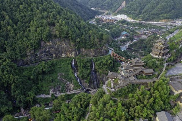(250712) -- SHANGRAO, July 12, 2025 (Xinhua) -- An aerial drone photo shows the Wangxian Valley Scenic Spot in Wangxian Township of Shangrao City, east China's Jiangxi Province, July 11, 2025. Once a granite mining quarry, Wangxian Valley has been transformed into a popular tourist destination following a government ban on disorderly mining, with its natural cliffs creatively repurposed into attractions such as cliffside hotels, cliff skywalks and waterfalls.
   Thanks to its ethereal and mystical views, this valley has garnered wide attention. In the first quarter of 2025, the valley hosted 615,800 visitors, generating 120 million yuan (about 16.73 million U.S. dollars) in revenue.
   This tourism boom has also benefited surrounding villagers. Many of them have opened shops and restaurants within the scenic area, while others have found relevent jobs. (Xinhua/Liu Jinhai)
