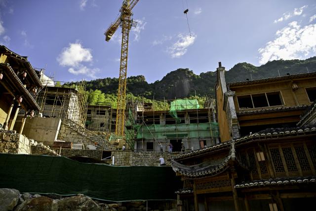 (250712) -- SHANGRAO, July 12, 2025 (Xinhua) -- Workers work on an extension project of the Wangxian Valley Scenic Spot in Wangxian Township of Shangrao City, east China's Jiangxi Province, July 11, 2025. Once a granite mining quarry, Wangxian Valley has been transformed into a popular tourist destination following a government ban on disorderly mining, with its natural cliffs creatively repurposed into attractions such as cliffside hotels, cliff skywalks and waterfalls.
   Thanks to its ethereal and mystical views, this valley has garnered wide attention. In the first quarter of 2025, the valley hosted 615,800 visitors, generating 120 million yuan (about 16.73 million U.S. dollars) in revenue.
   This tourism boom has also benefited surrounding villagers. Many of them have opened shops and restaurants within the scenic area, while others have found relevent jobs. (Xinhua/Liu Jinhai)