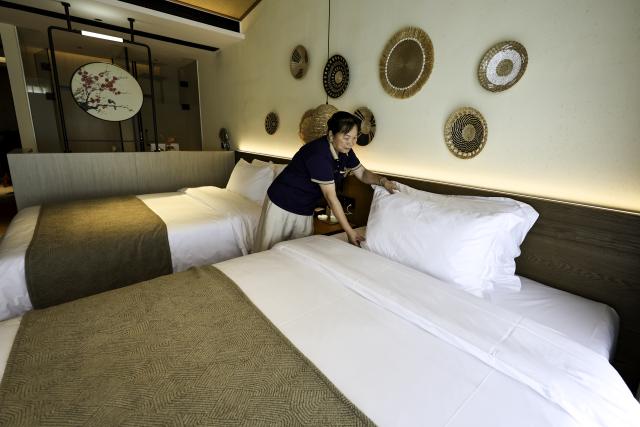 (250712) -- SHANGRAO, July 12, 2025 (Xinhua) -- A cleaner works at a homestay in Wangxian Township of Shangrao City, east China's Jiangxi Province, July 11, 2025. Once a granite mining quarry, Wangxian Valley has been transformed into a popular tourist destination following a government ban on disorderly mining, with its natural cliffs creatively repurposed into attractions such as cliffside hotels, cliff skywalks and waterfalls.
   Thanks to its ethereal and mystical views, this valley has garnered wide attention. In the first quarter of 2025, the valley hosted 615,800 visitors, generating 120 million yuan (about 16.73 million U.S. dollars) in revenue.
   This tourism boom has also benefited surrounding villagers. Many of them have opened shops and restaurants within the scenic area, while others have found relevent jobs. (Xinhua/Liu Jinhai)