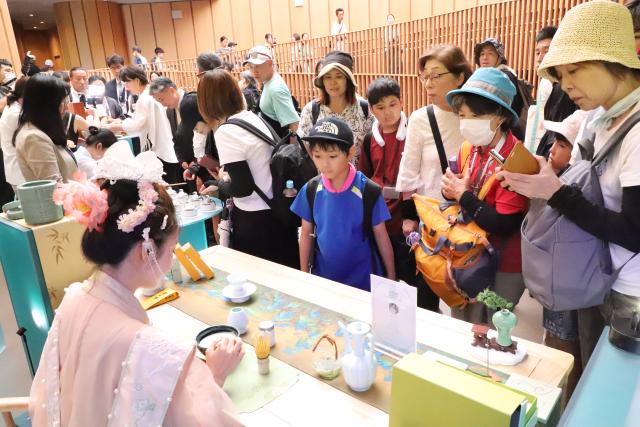 (250713) -- BEIJING, July 13, 2025 (Xinhua) -- People watch a tea art display at the "Zhejiang Week" of China Pavilion at the Expo 2025 Osaka in Osaka, Japan, on July 12, 2025. The "Zhejiang Week" of China Pavilion at the Expo 2025 Osaka kicked off on Saturday. (Xinhua/Li Ziyue)