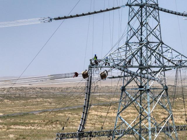 (250713) -- MINFENG COUNTY, July 13, 2025 (Xinhua) -- Staff members work on the final section of the 750-kilovolt (kV) loop in Minfeng County of Hotan Prefecture, northwest China's Xinjiang Uygur Autonomous Region, July 13, 2025. China has finished construction of a 4,197-km extra-high voltage power transmission loop around the Tarim Basin, home to the country's largest desert, marking a major infrastructure milestone in southern Xinjiang Uygur Autonomous Region in northwest China.
   The final section of the 750-kilovolt (kV) loop, now the country's largest of its kind, was connected on Sunday, capping a 15-year project involving nine substations and nearly 10,000 steel towers, according to a subsidiary of State Grid Xinjiang Electric Power Co., Ltd., which constructed the project. (Xinhua/Ding Lei)