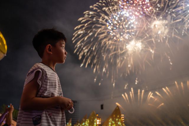 (250713) -- CHANGSHA, July 13, 2025 (Xinhua) -- A tourist enjoys a creative fireworks show in Liuyang City, central China's Hunan Province, July 12, 2025. Liuyang, a small city known as China's "fireworks capital," has organized 26 creative fireworks events in the first half of 2025. These events have attracted over 1.5 million tourists in total, stimulating consumer spending of nearly 4 billion yuan (about 558 million U.S. dollars). (Xinhua/Chen Sihan)