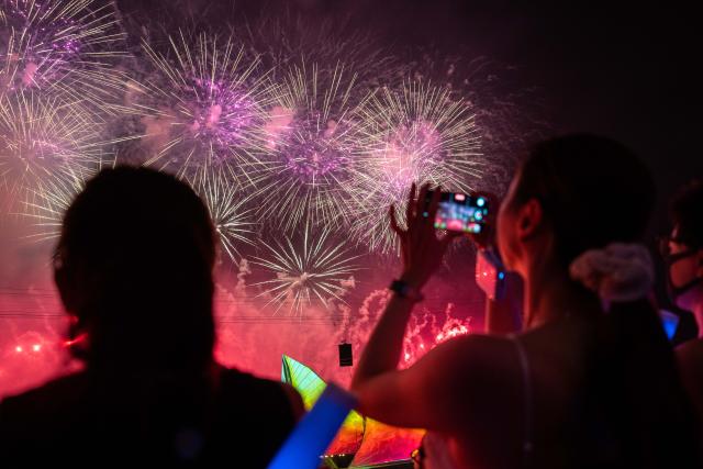 (250713) -- CHANGSHA, July 13, 2025 (Xinhua) -- Tourists take photos during a creative fireworks show in Liuyang City, central China's Hunan Province, July 12, 2025. Liuyang, a small city known as China's "fireworks capital," has organized 26 creative fireworks events in the first half of 2025. These events have attracted over 1.5 million tourists in total, stimulating consumer spending of nearly 4 billion yuan (about 558 million U.S. dollars). (Xinhua/Chen Sihan)
