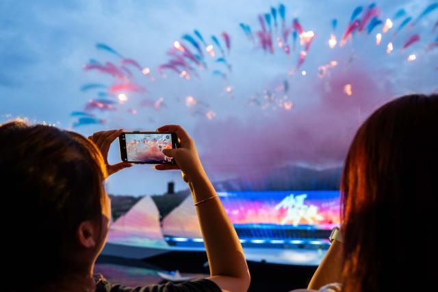 (250713) -- CHANGSHA, July 13, 2025 (Xinhua) -- Tourists take photos during a creative fireworks show in Liuyang City, central China's Hunan Province, July 12, 2025. Liuyang, a small city known as China's "fireworks capital," has organized 26 creative fireworks events in the first half of 2025. These events have attracted over 1.5 million tourists in total, stimulating consumer spending of nearly 4 billion yuan (about 558 million U.S. dollars). (Xinhua/Chen Sihan)