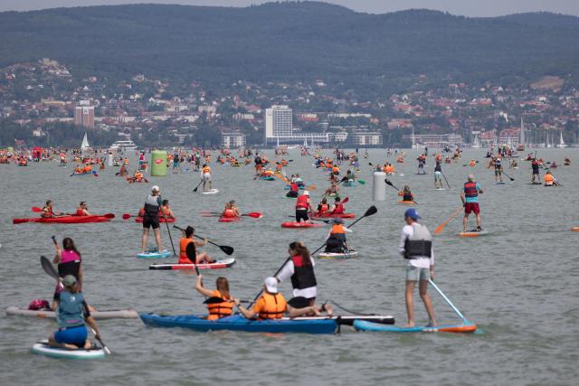 (250713) -- ZAMARDI, July 13, 2025 (Xinhua) -- People participate in the 2025 Hervis Balaton Crossing held on Lake Balaton between Zamardi and Tihany, Hungary on July 12, 2025. (Photo by Attila Volgyi/Xinhua)