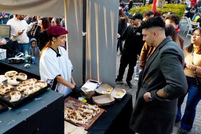 (250713) -- BUENOS AIRES, July 13, 2025 (Xinhua) -- A staff member sells empanadas at a food festival in Buenos Aires, Argentina, on July 12, 2025. A two-day food festival was held to celebrate Argentina's Independence Day in Buenos Aires. (Xinhua/Meng Dingbo)
