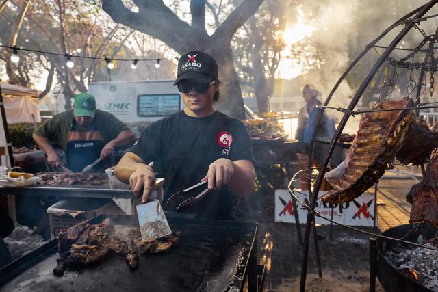 (250713) -- BUENOS AIRES, July 13, 2025 (Xinhua) -- Staff members roast meat at a food festival in Buenos Aires, Argentina, on July 12, 2025. A two-day food festival was held to celebrate Argentina's Independence Day in Buenos Aires. (Xinhua/Meng Dingbo)