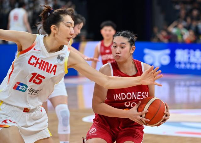 (250713) -- SHENZHEN, July 13, 2025 (Xinhua) -- Angelica Jennifer Candra (R) of Indonesia vies with Han Xu of China during the Group A match between China and Indonesia of FIBA Women's Asia Cup Division A in Shenzhen, south China's Guangdong Province, July 13, 2025. (Xinhua/Xiao Ennan)
