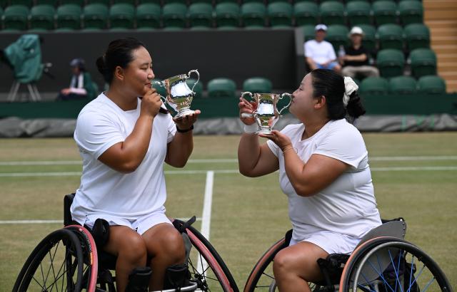 (250713) -- LONDON, July 13, 2025 (Xinhua) -- Li Xiaohui/Wang Ziying (R) kiss the trophies during the awarding ceremony after the women's wheelchair doubles final between Li Xiaohui/Wang Ziying of China and Angelica Bernal (Colombia)/ Ksenia Chasteau (France) at the Wimbledon Tennis Championships in London, Britain, July 13, 2025. (Xinhua/Zhao Dingzhe)