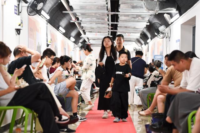 (250713) -- BEIJING, July 13, 2025 (Xinhua) -- Residents cool off at an air-raid shelter in Nanjing, east China's Jiangsu Province, July 13, 2025. A heatwave is sweeping multiple regions in China, prompting authorities to roll out measures to ensure job safety and stable production. (Photo by Yang Suping/Xinhua)
