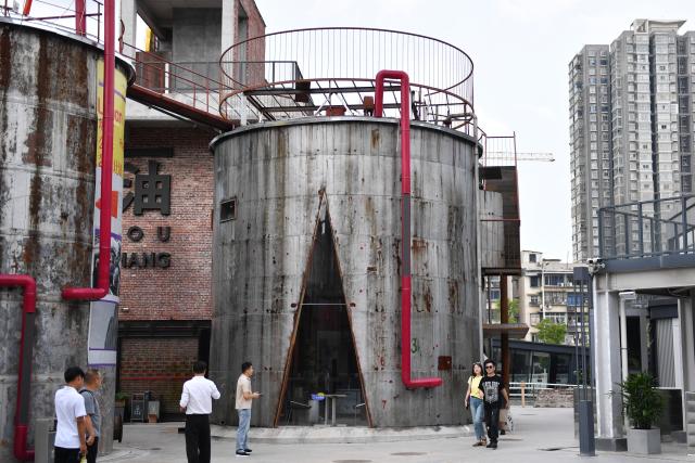(250713) -- CHANGSHA, July 13, 2025 (Xinhua) -- People tour in an obsolete oil depot in Changsha, central China's Hunan Province, July 13, 2025. In Tianxin District of Changsha City, 12 weathered oil tanks stand along the Xiangjiang River. This site formerly served as the oil depot for the city, witnessing an olden time when citizens fetch edible oil with ration coupons. The facility was largely left unused since the 1990s.
    This July saw the reopening of this industrial heritage, with oil tanks and auxiliary facilities transformed into vibrant cafes, exhibition halls, art stores, among others, featuring a blend of industrial design and diverse consumer experiences that attract both residents and tourists. (Xinhua/Chen Zhenhai)