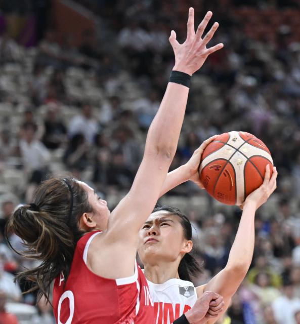 (250713) -- SHENZHEN, July 13, 2025 (Xinhua) -- Wang Siyu (R) of China competes during the Group A match between China and Indonesia of FIBA Women's Asia Cup Division A in Shenzhen, south China's Guangdong Province, July 13, 2025. (Xinhua/Deng Hua)