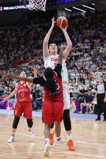 (250713) -- SHENZHEN, July 13, 2025 (Xinhua) -- Zhang Ziyu (R) of China vies with Kim Pierre-Louis (C) of Indonesia during the Group A match between China and Indonesia of FIBA Women's Asia Cup Division A in Shenzhen, south China's Guangdong Province, July 13, 2025. (Xinhua/Liang Xu)