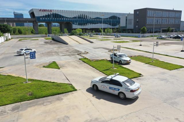 (250715) -- DONGYANG, July 15, 2025 (Xinhua) -- A drone photo taken on July 2, 2025 shows trainees driving AI-driven training vehicles at the Xinlong driving school in Dongyang, east China's Zhejiang Province. The driving school has introduced an AI-assisted teaching system, which includes AI-driven training vehicles, indoor driving simulators, and AI-powered data management system. Equipped with 16 vehicle-borne radars and visual assistance system, each AI-driven training vehicle serves as an intelligent alternative to a driving coach, providing comprehensive and safe guidance for trainees. (Photo by Bao Kangxuan/Xinhua)