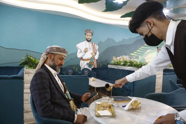 (250715) -- SANAA, July 15, 2025 (Xinhua) -- A staff member serves a customer at the Haraaz Coffee in Sanaa, Yemen, on July 14, 2025. (Photo by Mohammed Mohammed/Xinhua)