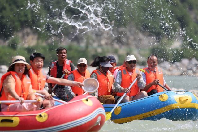 (250716) -- HUIXIAN, July 16, 2025 (Xinhua) -- People raft in inflatable boats on Jiangling River in Huixian County, northwest China's Gansu Province, July 15, 2025. (Xinhua/Chen Bin)