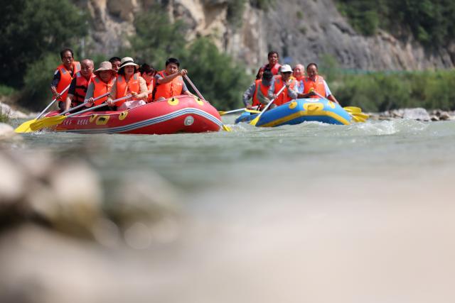 (250716) -- HUIXIAN, July 16, 2025 (Xinhua) -- People raft in inflatable boats on Jiangling River in Huixian County, northwest China's Gansu Province, July 15, 2025. (Xinhua/Chen Bin)
