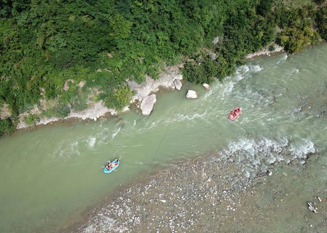 (250716) -- HUIXIAN, July 16, 2025 (Xinhua) -- An aerial drone photo taken on July 15, 2025 shows people rafting in inflatable boats on Jiangling River in Huixian County, northwest China's Gansu Province. (Xinhua/Ma Ning)