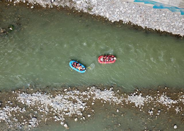 (250716) -- HUIXIAN, July 16, 2025 (Xinhua) -- An aerial drone photo taken on July 15, 2025 shows people rafting in inflatable boats on Jiangling River in Huixian County, northwest China's Gansu Province. (Xinhua/Ma Ning)