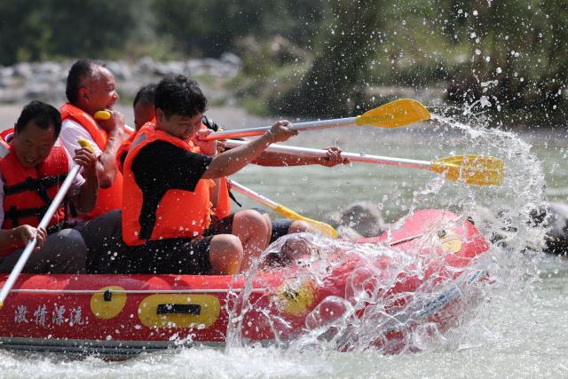 (250716) -- HUIXIAN, July 16, 2025 (Xinhua) -- People raft in an inflatable boat on Jiangling River in Huixian County, northwest China's Gansu Province, July 15, 2025. (Xinhua/Chen Bin)