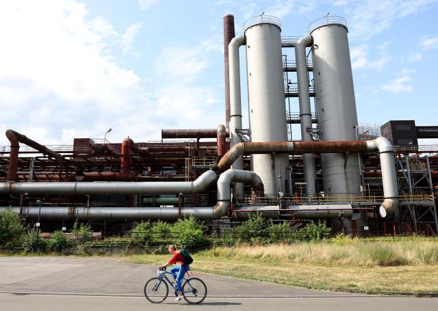 (250716) -- ESSEN, July 16, 2025 (Xinhua) -- A woman rides through the Zollverein Coal Mine Industrial Complex in Essen, Germany, July 15, 2025. (Xinhua/Zhang Chen)