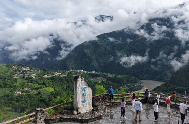 (250716) -- KUNMING, July 16, 2025 (Xinhua) -- An aerial drone photo taken on July 15, 2025 shows tourists visiting Bingzhongluo Township in Gongshan Dulong and Nu Autonomous County, southwest China's Yunnan Province. Known for its stunning nature beauty, Yunnan Province has cultivated a summer tourism industry, offering tourists diverse experiences amid forests, snow-capped mountains, wetlands, and flower fields. (Photo by Liang Zhiqiang/Xinhua)
