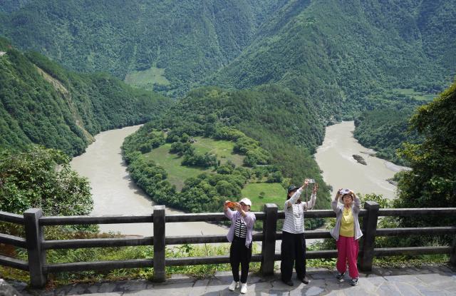 (250716) -- KUNMING, July 16, 2025 (Xinhua) -- Tourists enjoy the view of the Nujiang River in Gongshan Dulong and Nu Autonomous County, southwest China's Yunnan Province, July 15, 2025. Known for its stunning nature beauty, Yunnan Province has cultivated a summer tourism industry, offering tourists diverse experiences amid forests, snow-capped mountains, wetlands, and flower fields. (Photo by Liang Zhiqiang/Xinhua)