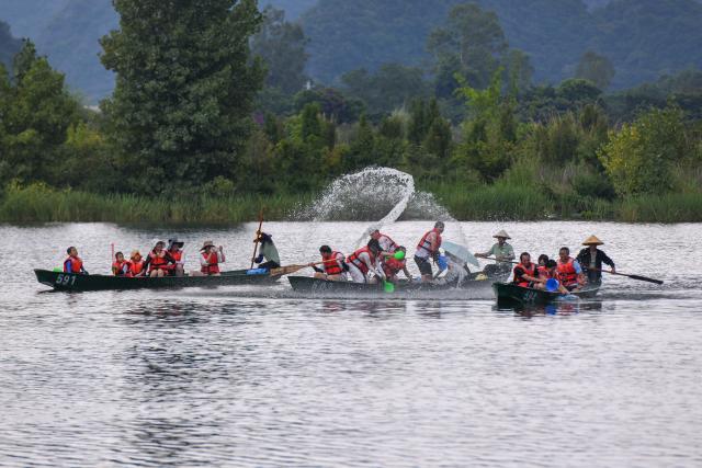 (250717) -- QIUBEI, July 17, 2025 (Xinhua) -- Tourists splash water on each other while rowing boats at the Puzhehei scenic area in Qiubei County, Wenshan Zhuang and Miao Autonomous Prefecture, southwest China's Yunnan Province, July 15, 2025. The beautiful scenery of Puzhehei, along with the rich amusement facilities there, has attracted lots of visitors during the summer. (Photo by Peng Yikai/Xinhua)