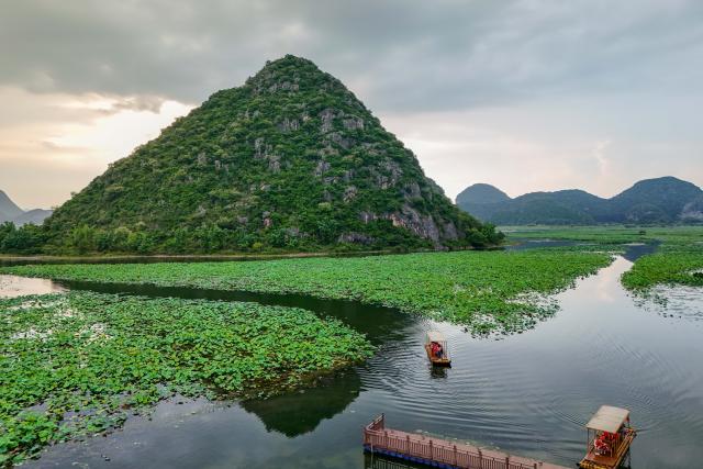 (250717) -- QIUBEI, July 17, 2025 (Xinhua) -- A drone photo taken on July 15, 2025 shows tourists taking a boat at the Puzhehei scenic area in Qiubei County, Wenshan Zhuang and Miao Autonomous Prefecture, southwest China's Yunnan Province. The beautiful scenery of Puzhehei, along with the rich amusement facilities there, has attracted lots of visitors during the summer. (Photo by Peng Yikai/Xinhua)