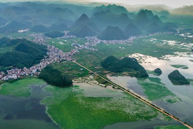 (250717) -- QIUBEI, July 17, 2025 (Xinhua) -- A drone photo taken on July 15, 2025 shows the scenery of the Puzhehei scenic area in Qiubei County, Wenshan Zhuang and Miao Autonomous Prefecture, southwest China's Yunnan Province. The beautiful scenery of Puzhehei, along with the rich amusement facilities there, has attracted lots of visitors during the summer. (Photo by Peng Yikai/Xinhua)