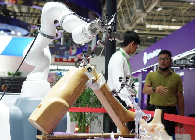 (250717) -- BEIJING, July 17, 2025 (Xinhua) -- An AI-powered orthopedic surgical robot is seen in the Healthy Life Chain area of the third China International Supply Chain Expo (CISCE) in Beijing, capital of China, July 17, 2025. Held from July 16 to 20, the 2025 CISCE kicked off in Beijing on Wednesday. A key innovation for this edition is the "Debut Zone," dedicated to the global premieres of new products, technologies, and ecosystems, showcasing breakthrough innovations that drive industrial collaboration. (Xinhua/Zhang Chenlin)