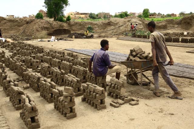 (250718) -- OMDURMAN, July 18, 2025 (Xinhua) -- A worker transports mud bricks in Omdurman, north of the Sudanese capital Khartoum, Sudan, July 17, 2025. Following the Sudanese army's recapture of Khartoum from the paramilitary Rapid Support Forces, displaced residents began returning home. Facing ruined homes and scarce resources, they started to rebuild houses using whatever materials available. Along the Nile in Khartoum and Omdurman, workers shape seasonal silt into bricks, then dry and fire them as generations before. (Photo by Mohamed Khidir/Xinhua)