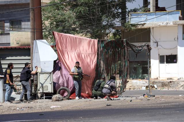 (250718) -- SWEIDA, July 18, 2025 (Xinhua) -- Tribal fighters take cover during clashes in the town of Wolgha, western countryside of Sweida, southern Syria, on July 18, 2025. The Syrian interim authorities on Friday issued a call for restraint amid escalating violence in the southern province of Sweida, pledging to deploy forces to contain the conflict. (Str/Xinhua)