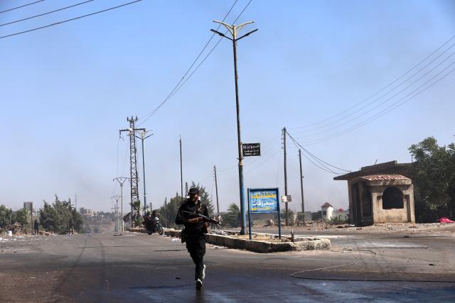 (250718) -- SWEIDA, July 18, 2025 (Xinhua) -- A bedouin fighter runs to cross a road in the town of Wolgha, western countryside of Sweida, southern Syria, on July 18, 2025. The Syrian interim authorities on Friday issued a call for restraint amid escalating violence in the southern province of Sweida, pledging to deploy forces to contain the conflict. (Str/Xinhua)