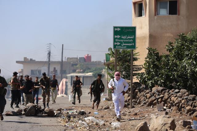 (250718) -- SWEIDA, July 18, 2025 (Xinhua) -- Bedouin fighters advance through the town of Wolgha in the western countryside of Sweida, southern Syria, on July 18, 2025. The Syrian interim authorities on Friday issued a call for restraint amid escalating violence in the southern province of Sweida, pledging to deploy forces to contain the conflict. (Str/Xinhua)