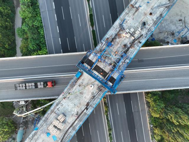 (250719) -- BEIJING, July 19, 2025 (Xinhua) -- An aerial drone photo taken on July 18, 2025 shows a construction site of the middle span of the continuous beam for Baoding East super major bridge of the Xiong'an-Xinzhou high-speed railway, which crosses over the Beijing-Hong Kong-Macao expressway, in Baoding, north China's Hebei Province. The middle span built by China Railway 14th Bureau Group Co., Ltd. was successfully closed on Friday.
   The Xiong'an-Xinzhou high-speed railway is an important section of Beijing-Kunming high-speed railway that belongs to a greater high-speed rail artery network consisting eight vertical lines and eight horizontal lines in the country. (Xinhua/Xing Guangli)