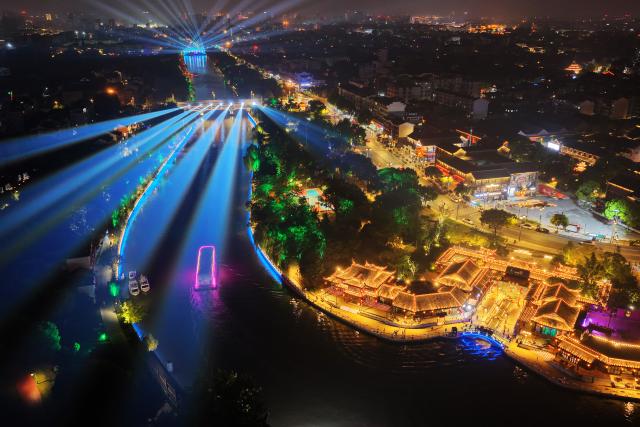 (250719) -- BEIJING, July 19, 2025 (Xinhua) -- An aerial drone photo shows a cruise ship sailing on the ancient canal in Yangzhou, east China's Jiangsu Province, July 17, 2025. In recent years, Yangzhou has implemented a night landscape upgrade project of the ancient canal, and organized night tours and night markets to improve tourists' consumption experience. (Photo by Meng Delong/Xinhua)