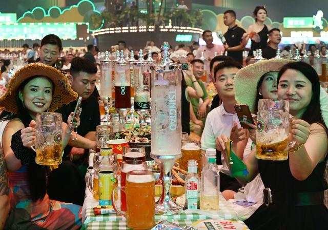 (250719) -- BEIJING, July 19, 2025 (Xinhua) -- People enjoy beer during the 35th Qingdao International Beer Festival at the Xihai'an (West Coast) New Area in Qingdao, east China's Shandong Province, July 18, 2025. The 30-day festival kicked off here on Friday, gathering over 2,300 domestic and foreign beer brands. The festival also features a series of activities, including art parades, craft beer competition, concerts, King of Beer competition, animation carnival and fashion sports festival. (Xinhua/Li Ziheng)