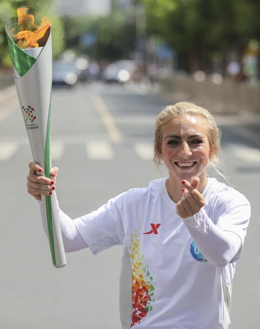 (250726) -- MEISHAN (SICHUAN), July 26, 2025 (Xinhua) -- Torch bearer Sofia Olofsson holds the torch during the World Games 2025 Torch Relay in Meishan, southwest China's Sichuan Province, July 26, 2025. (Xinhua/Wang Xiang)