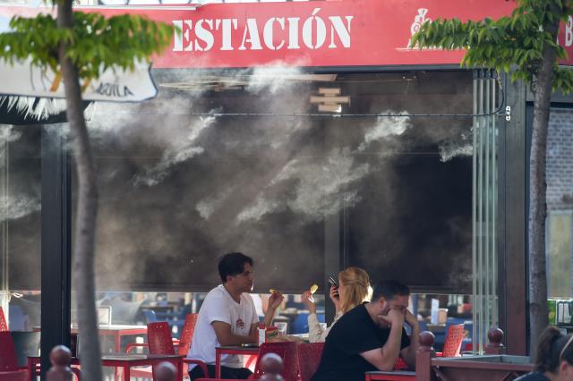 (250918) -- MADRID, Sept. 18, 2025 (Xinhua) -- Customers have meals near a cooling device in Madrid, Spain, Sept. 17, 2025.
  Spain's State Meteorological Agency (AEMET) said that it will be hotter than usual in most areas through this September, as temperatures in some southern areas are expected to exceed 38 degrees Celsius. (Photo by Gustavo Valiente/Xinhua)