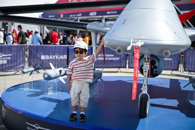 (250918) -- ISTANBUL, Sept. 18, 2025 (Xinhua) -- A child poses for a photo with a drone exhibit at the technology event TEKNOFEST in Istanbul, Türkiye, Sept. 17, 2025.
  The five-day event kicked off here on Wednesday, showcasing sci-tech advancements in fields such as aerospace, education and healthcare. (Xinhua/Liu Lei)